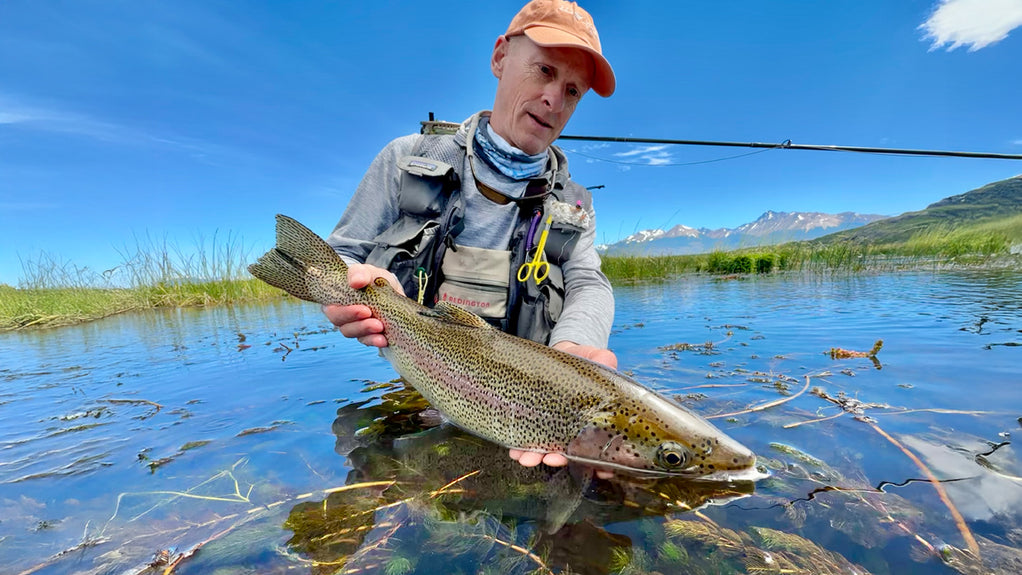 crossing brook on step-stones with fishing pole and can Las Pampas Lodge