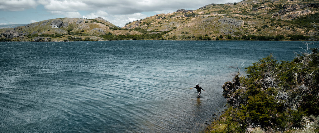 Wide shot of man casting long distance in a lake