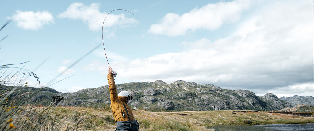 Angler with bent rod held high with a fish on