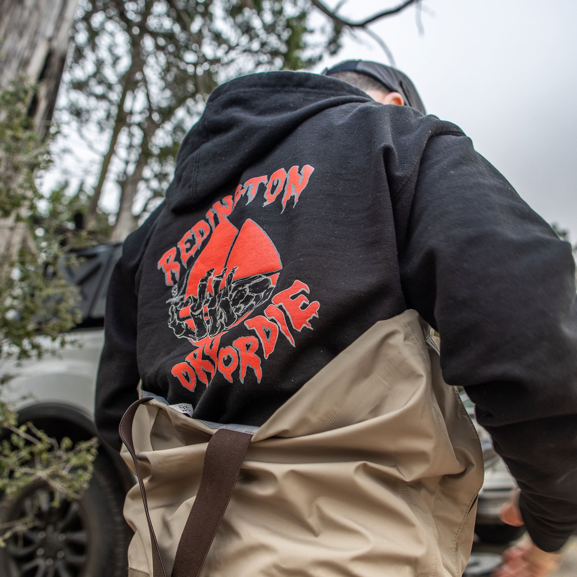 Back view of a black zip hoodie with a red Redington graphic design on the back.